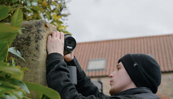 MyHomeCCTV - Our Approach - Man stood installing a camera onto a wall outside of someone's home.